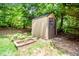 A light tan storage shed is placed near raised garden beds surrounded by lush green trees at 212 Heidinger Dr, Cary, NC 27511