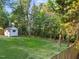 This serene backyard boasts a lush green lawn, mature trees, and a charming shed, ideal for storage or hobbies at 2205 Bufflehead Rd, Raleigh, NC 27616