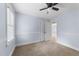 Carpeted bedroom with neutral walls, bright natural light, a ceiling fan, and double door closet at 2205 Bufflehead Rd, Raleigh, NC 27616