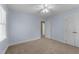 A carpeted bedroom with light blue walls, a ceiling fan, closet, and entry door at 2205 Bufflehead Rd, Raleigh, NC 27616