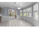 Open dining area with white tile flooring, ample windows, and backyard access at 2205 Bufflehead Rd, Raleigh, NC 27616
