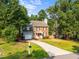Charming two-story brick home with lush landscaping, a paved driveway, and attached garage at 2205 Bufflehead Rd, Raleigh, NC 27616
