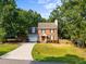 Two-story brick home with attached garage and fenced yard nestled among mature trees at 2205 Bufflehead Rd, Raleigh, NC 27616