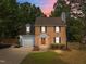 Inviting two-story brick home with gray siding, a tidy yard, and an orange front door at 2205 Bufflehead Rd, Raleigh, NC 27616