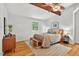 Bedroom features hardwood floors, exposed beams, and a comfortable king bed at 224 Fleming Dr, Durham, NC 27712
