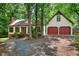 Charming home with a two-car garage and brick chimney surrounded by lush trees and a gravel driveway at 224 Fleming Dr, Durham, NC 27712