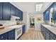 Charming blue kitchen featuring ample cabinetry, an electric range, and views into the dining area at 224 Fleming Dr, Durham, NC 27712