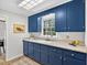 Well-lit blue kitchen with plenty of countertop space, cabinetry, and a sink beneath a window at 224 Fleming Dr, Durham, NC 27712