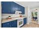 Functional blue kitchen with essential appliances, ample cabinetry, and a pass-through to the dining area at 224 Fleming Dr, Durham, NC 27712