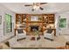 Inviting living room with a brick fireplace, built-in bookshelves, ceiling fan, and neutral tones at 224 Fleming Dr, Durham, NC 27712
