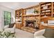 Comfortable living room with a brick fireplace, built-in shelves, and a large window overlooking the yard at 224 Fleming Dr, Durham, NC 27712