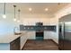 Modern kitchen featuring granite counters, stainless appliances, and white cabinetry at 2323 Gathering Sq Ct, Fuquay Varina, NC 27526