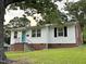 Charming home showcasing a well-maintained lawn, complemented by a bright teal door at 2331 Kennington Rd, Raleigh, NC 27610