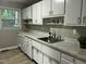 Bright kitchen features white cabinetry, marble countertops, stainless sink, and modern appliances at 2331 Kennington Rd, Raleigh, NC 27610