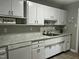 Bright kitchen features white cabinetry, marble countertops, stainless sink, and modern appliances at 2331 Kennington Rd, Raleigh, NC 27610