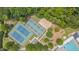 Aerial view of the community tennis courts, playground, and pool, surrounded by mature trees at 2420 Rogerson St, Raleigh, NC 27614