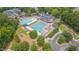 Aerial view of the community pool, playground and clubhouse surrounded by mature trees and manicured lawns at 2420 Rogerson St, Raleigh, NC 27614