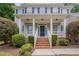 Inviting front porch with brick steps, white railings, and a dark blue front door at 2420 Rogerson St, Raleigh, NC 27614