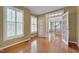 Bright living room with hardwood floors, plantation shutters, and an open doorway to the foyer at 2420 Rogerson St, Raleigh, NC 27614