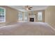 Comfortable living room featuring a fireplace, ceiling fan, and large windows providing natural light at 2420 Rogerson St, Raleigh, NC 27614