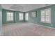 This bedroom features a tray ceiling, neutral carpet, multiple windows with white shutters and pale teal colored walls at 2420 Rogerson St, Raleigh, NC 27614