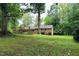 Brick house with an expansive green lawn surrounded by mature trees at 2440 Gardner Holt Rd, Burlington, NC 27215