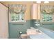Charming bathroom featuring blue tile, leafy window curtains, a mirror and updated fixtures at 2440 Gardner Holt Rd, Burlington, NC 27215