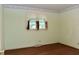 Bedroom with hardwood floors, decorative wallpaper and a window with stylish curtains and dark shutters at 2440 Gardner Holt Rd, Burlington, NC 27215