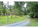 Long, gravel driveway surrounded by mature trees, adding to the home's privacy at 2440 Gardner Holt Rd, Burlington, NC 27215