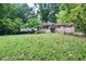 Quaint one-story home with a spacious front lawn covered in autumn leaves and lush foliage at 2440 Gardner Holt Rd, Burlington, NC 27215