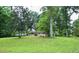 Single-story home nestled among mature trees, offering privacy and a serene setting at 2440 Gardner Holt Rd, Burlington, NC 27215