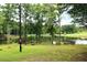 Picturesque view of a pond surrounded by mature trees and lush greenery; a tranquil setting at 2440 Gardner Holt Rd, Burlington, NC 27215