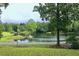 Scenic view of the pond with a charming gazebo and a small pier; lush, green lawn in the foreground at 2440 Gardner Holt Rd, Burlington, NC 27215