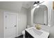 Renovated bathroom featuring black and gold fixtures and a large arched mirror at 2704 Farnborough Rd, Raleigh, NC 27613