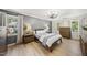 Cozy bedroom with wood flooring, two windows, and a grey accent wall for a relaxing ambiance at 2704 Farnborough Rd, Raleigh, NC 27613