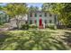 Traditional two-story home with a red front door, attached garage, and a well-manicured lawn and landscaping at 2704 Farnborough Rd, Raleigh, NC 27613