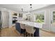Modern kitchen features a large island with seating and stainless steel appliances, all bathed in natural light at 2704 Farnborough Rd, Raleigh, NC 27613