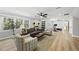 Inviting living room featuring hardwood floors, comfortable seating, a ceiling fan, and large windows for natural light at 2704 Farnborough Rd, Raleigh, NC 27613