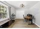 Well-lit office space featuring a modern adjustable desk, comfortable chair, and a sound-dampening wall panel at 2704 Farnborough Rd, Raleigh, NC 27613