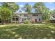 Spacious home with a lush green lawn, patio, and mature trees, perfect for outdoor living and entertaining at 2704 Farnborough Rd, Raleigh, NC 27613