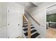 Staircase with black stairs and wooden handrail at 2704 Farnborough Rd, Raleigh, NC 27613