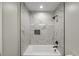 Bathroom with tub and shower featuring marble-like tile at 2803 Atlantic St, Durham, NC 27707