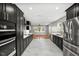 Open kitchen with black cabinets, stainless appliances, quartz countertops, and hardwood flooring at 2803 Atlantic St, Durham, NC 27707