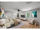 Spacious staged bedroom with light wood floors, ceiling fan, and views to the bathroom at 2803 Atlantic St, Durham, NC 27707