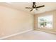 Neutral bedroom with carpeted floor, ceiling fan, and a window overlooking the neighborhood at 2808 Carter Finley Pl, Raleigh, NC 27606
