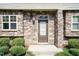 Close-up of the front door showcasing the stone facade and manicured shrubs at the townhome entrance at 2808 Carter Finley Pl, Raleigh, NC 27606