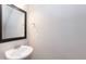 The half bathroom has a pedestal sink with black-framed mirror and neutral walls at 2808 Carter Finley Pl, Raleigh, NC 27606