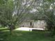 View of the backyard with mature trees and a patio area, offering a serene and private outdoor space at 3008 River Hill Ln, Burlington, NC 27217