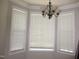 Dining room featuring a bay window with blinds and a chandelier, offering natural light at 3008 River Hill Ln, Burlington, NC 27217