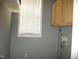 Laundry room with upper cabinets, window with blinds, and washer hookups at 3008 River Hill Ln, Burlington, NC 27217